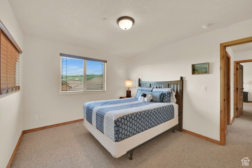 Bedroom featuring light colored carpet