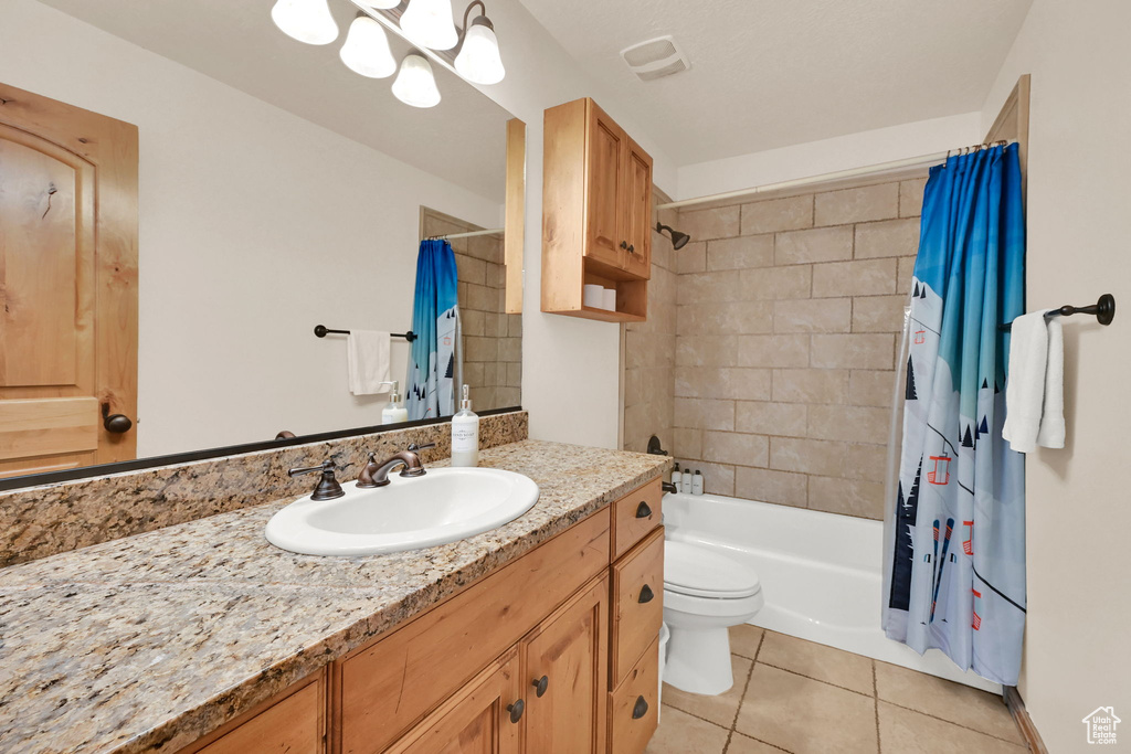 Bathroom with tile patterned floors, vanity, and shower / bath combo with shower curtain