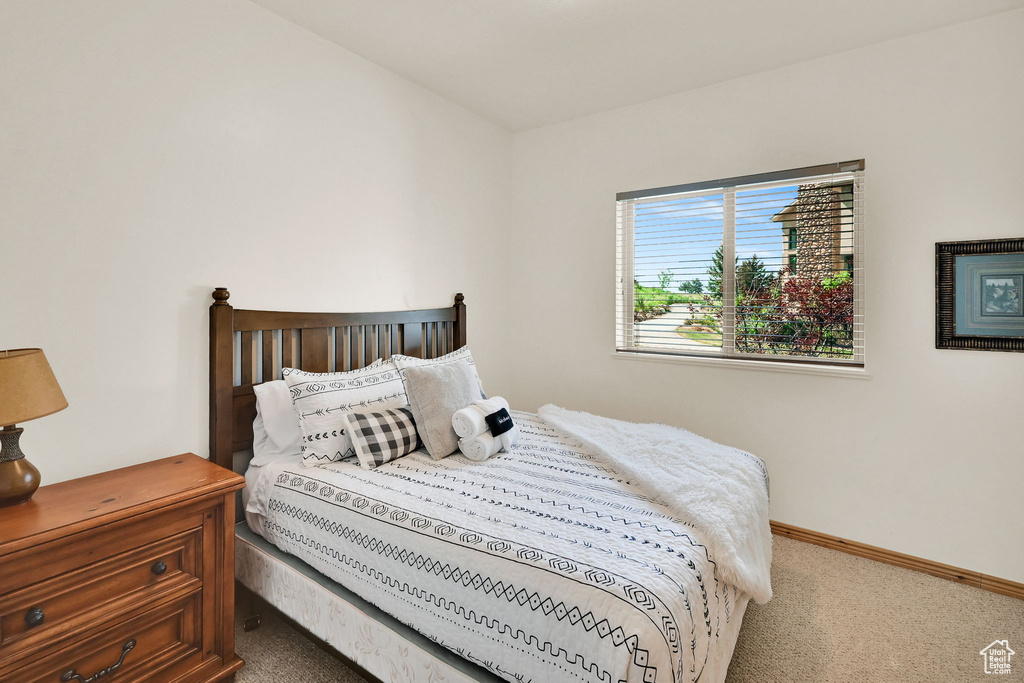 Bedroom featuring carpet and baseboards