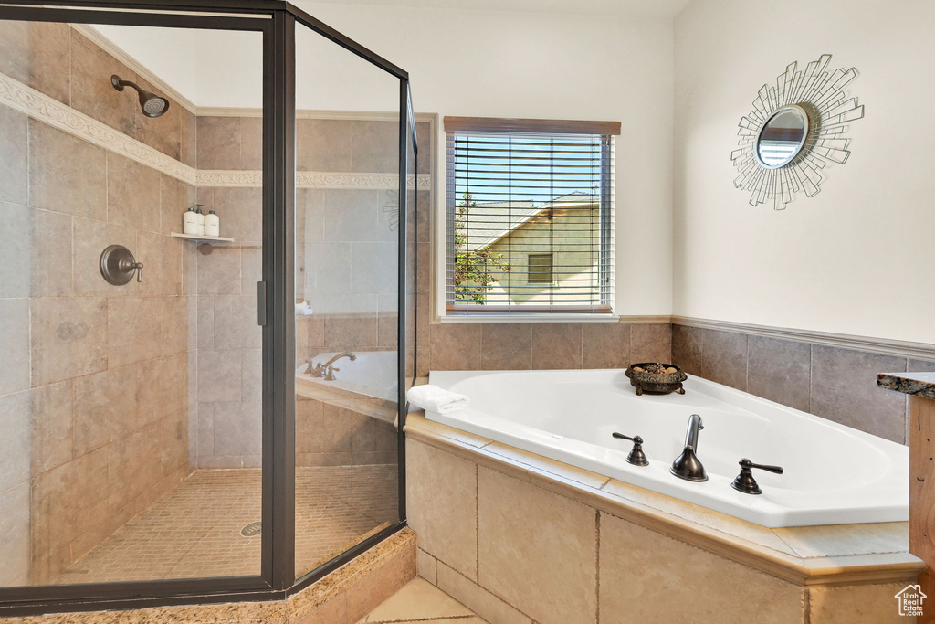 Bathroom featuring a shower stall, a bath, and tile patterned floors
