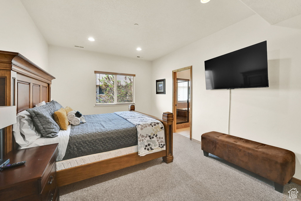 Bedroom featuring recessed lighting, light carpet, and connected bathroom