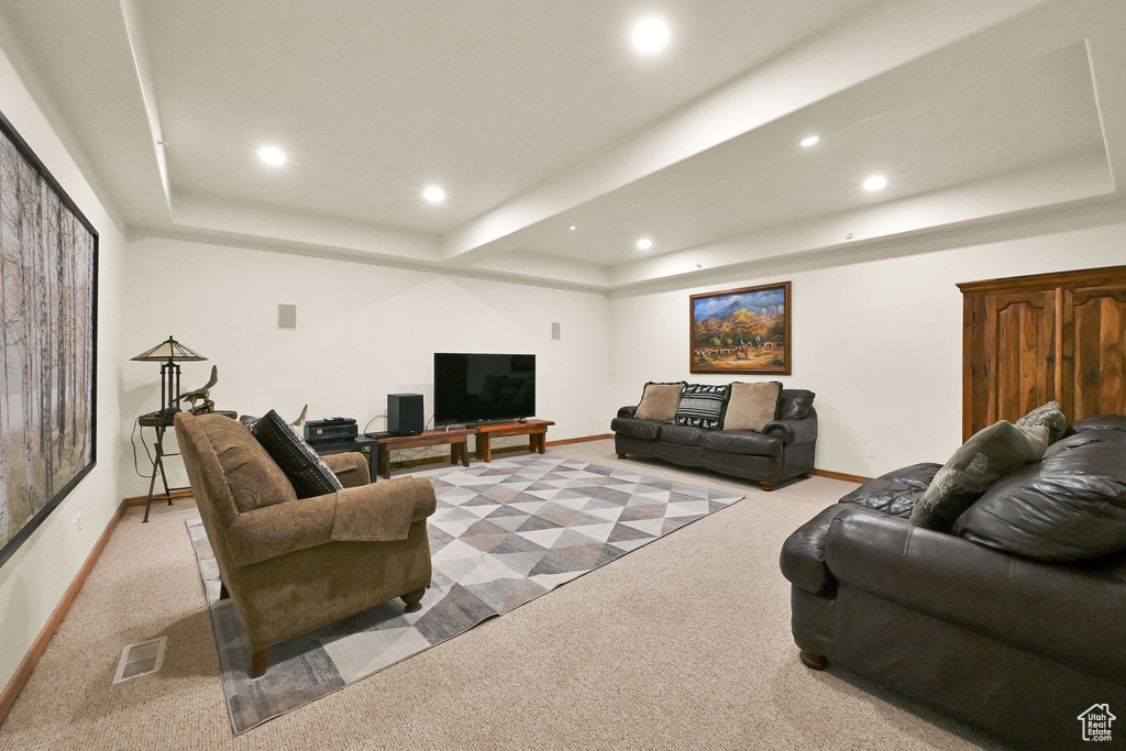 Living room with a tray ceiling, light carpet, and recessed lighting