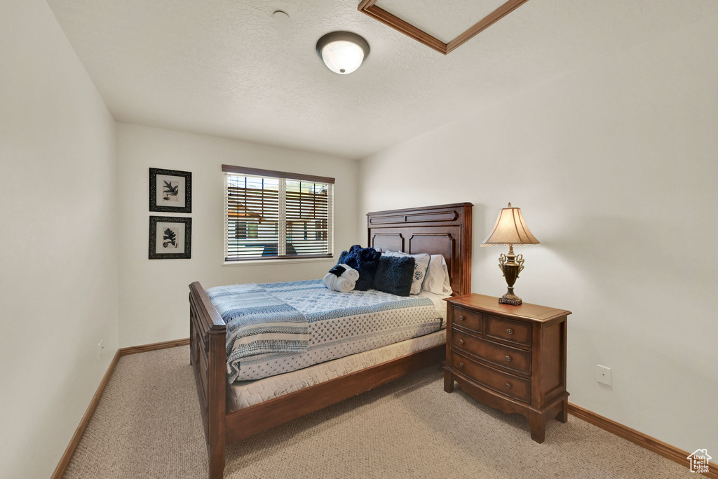 Bedroom with light carpet and a textured ceiling
