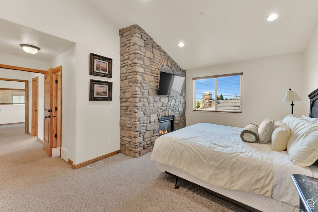 Carpeted bedroom with vaulted ceiling, a fireplace, and recessed lighting