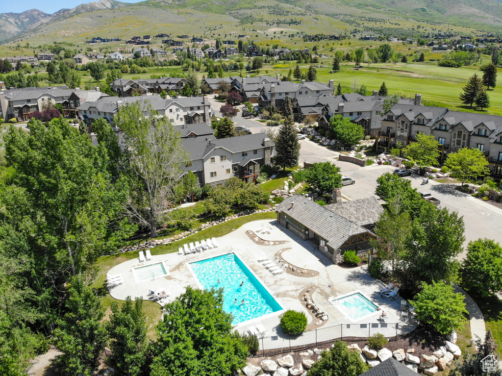 Aerial view of residential area with a pool area and a mountainous background