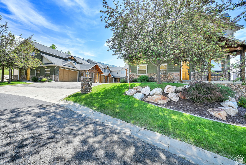 Craftsman inspired home with stone siding, a garage, and driveway