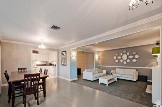 Dining space with a chandelier and crown molding