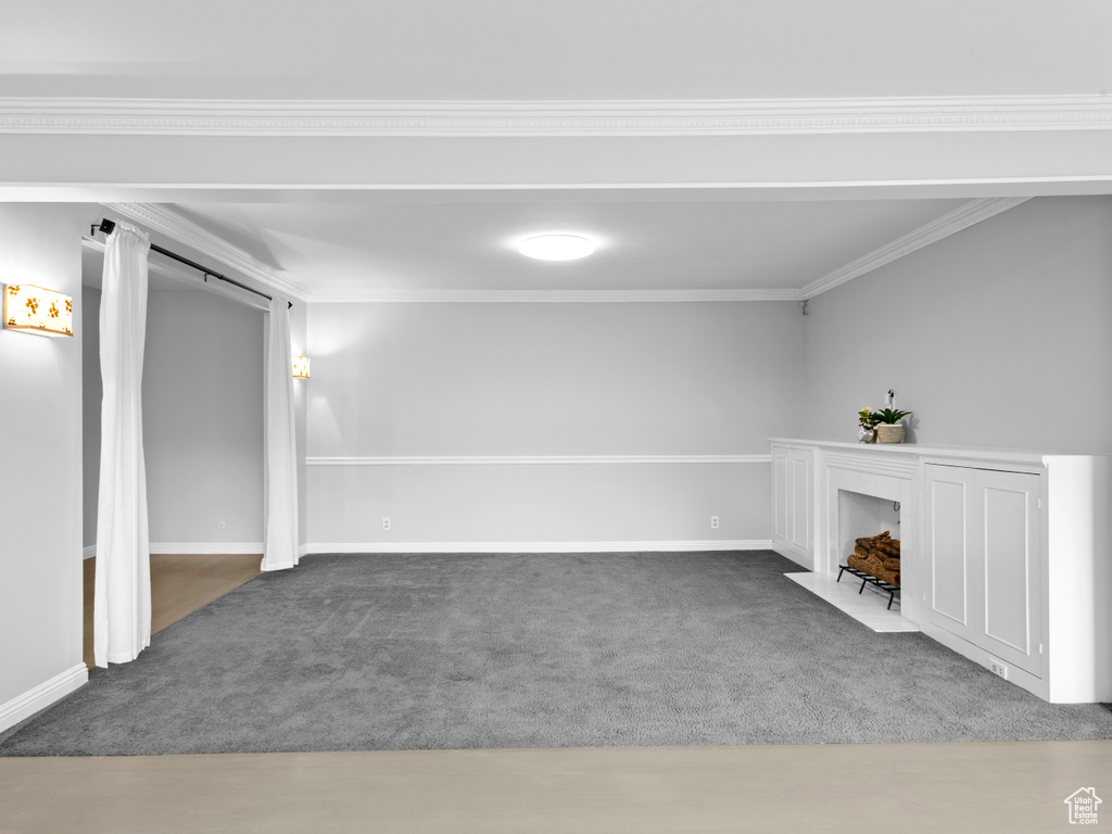 Unfurnished living room with carpet and crown molding