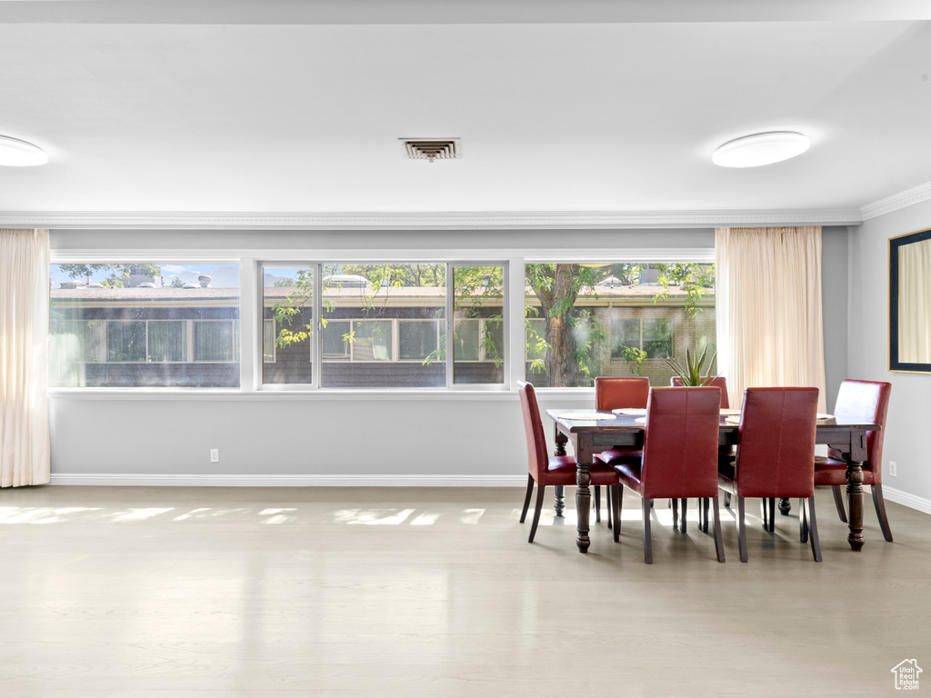 Dining space featuring baseboards and crown molding