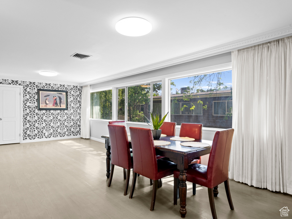 Dining room with wallpapered walls and wood finished floors