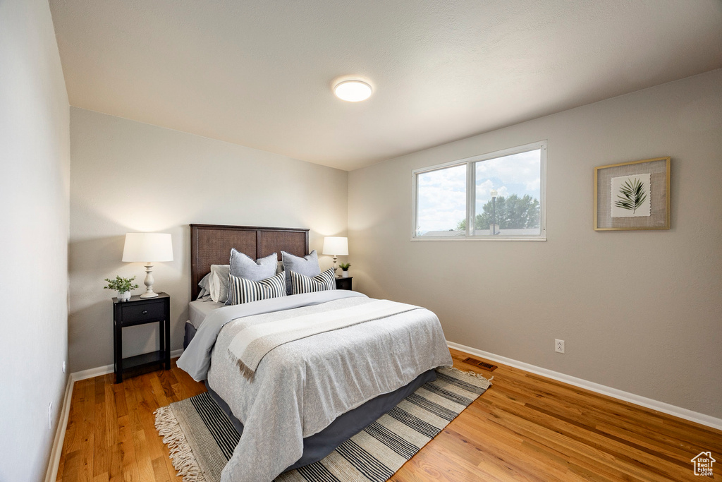 Bedroom with baseboards and wood finished floors