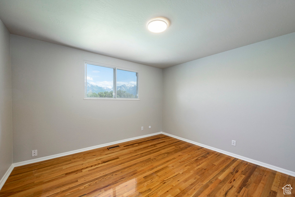 Unfurnished room featuring baseboards and wood finished floors