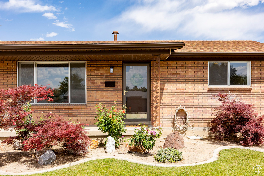View of front of property with brick siding and a shingled roof