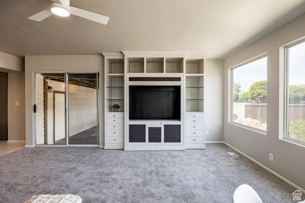 Unfurnished living room featuring carpet flooring and ceiling fan