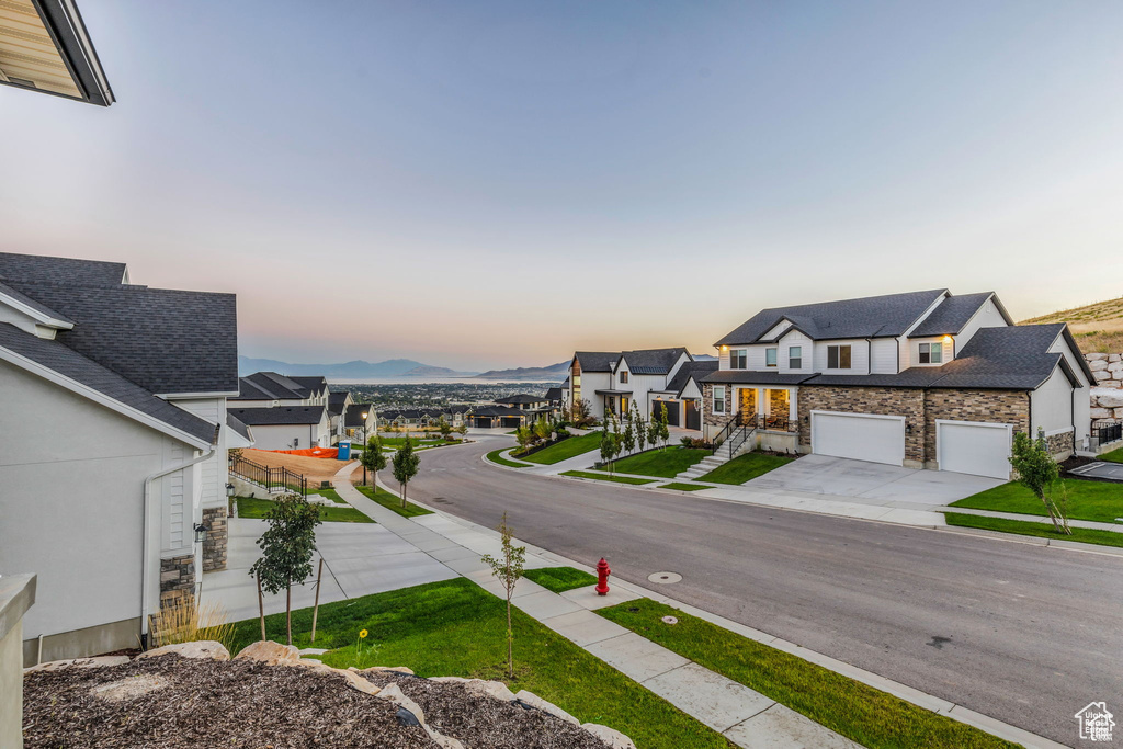 View of asphalt street featuring sidewalks, a mountain view, and curbs