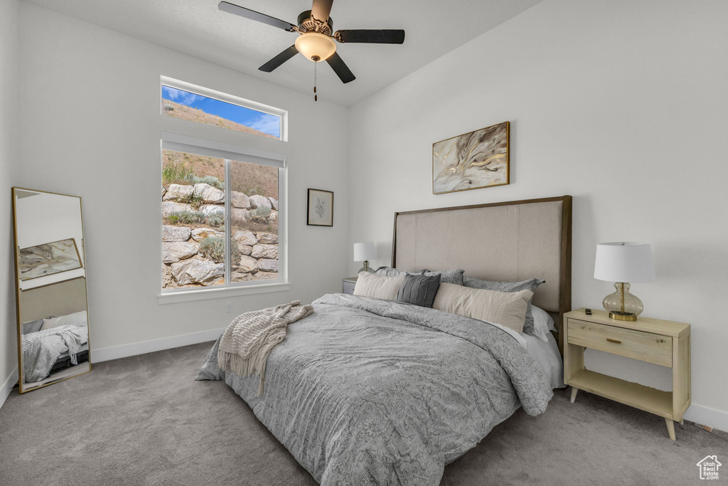 Carpeted bedroom featuring baseboards and ceiling fan