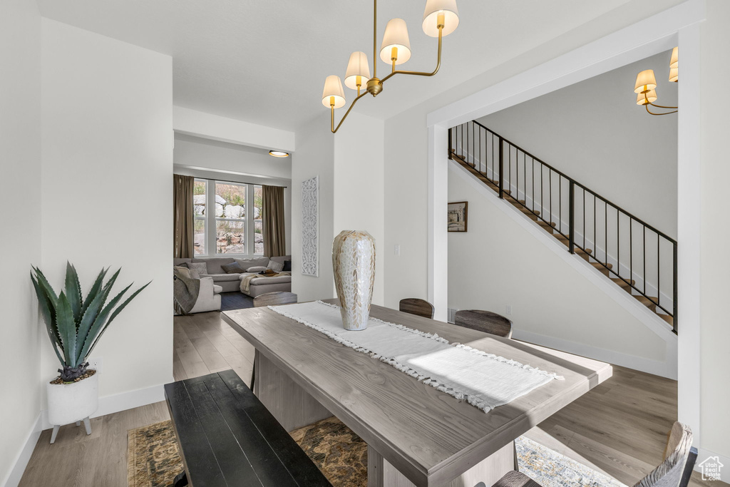 Dining room featuring a chandelier, wood finished floors, and stairway