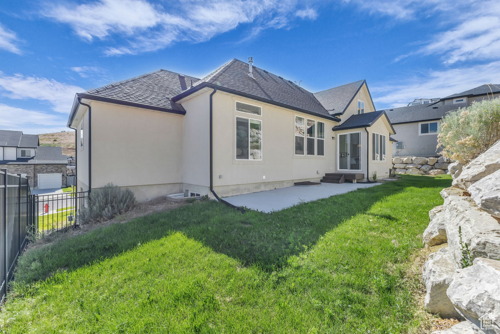 Back of property with a patio area, a shingled roof, stucco siding, and entry steps