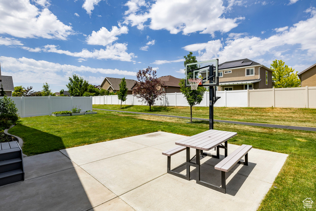 Fenced backyard with a patio area, outdoor dining area, and a residential view