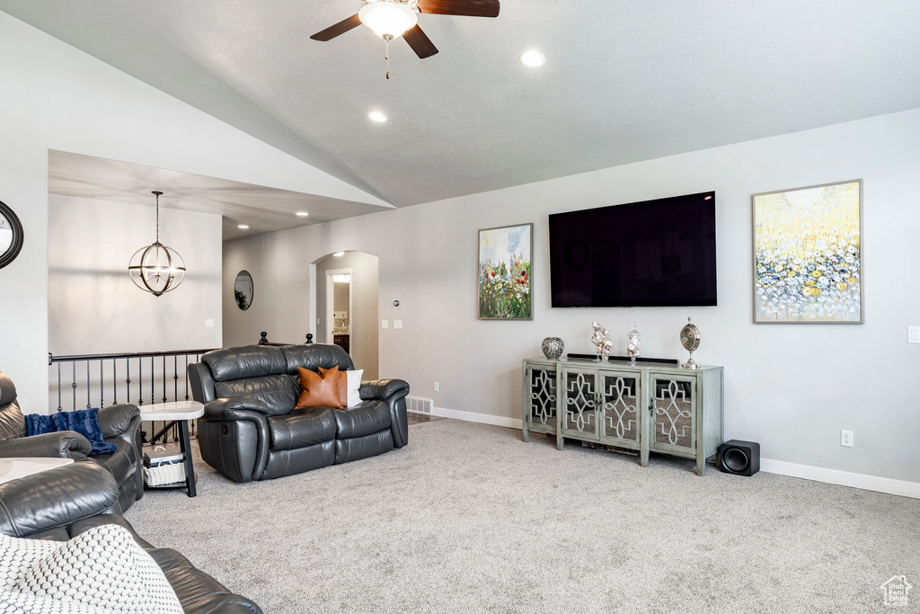 Living room with arched walkways, ceiling fan, carpet, recessed lighting, and lofted ceiling