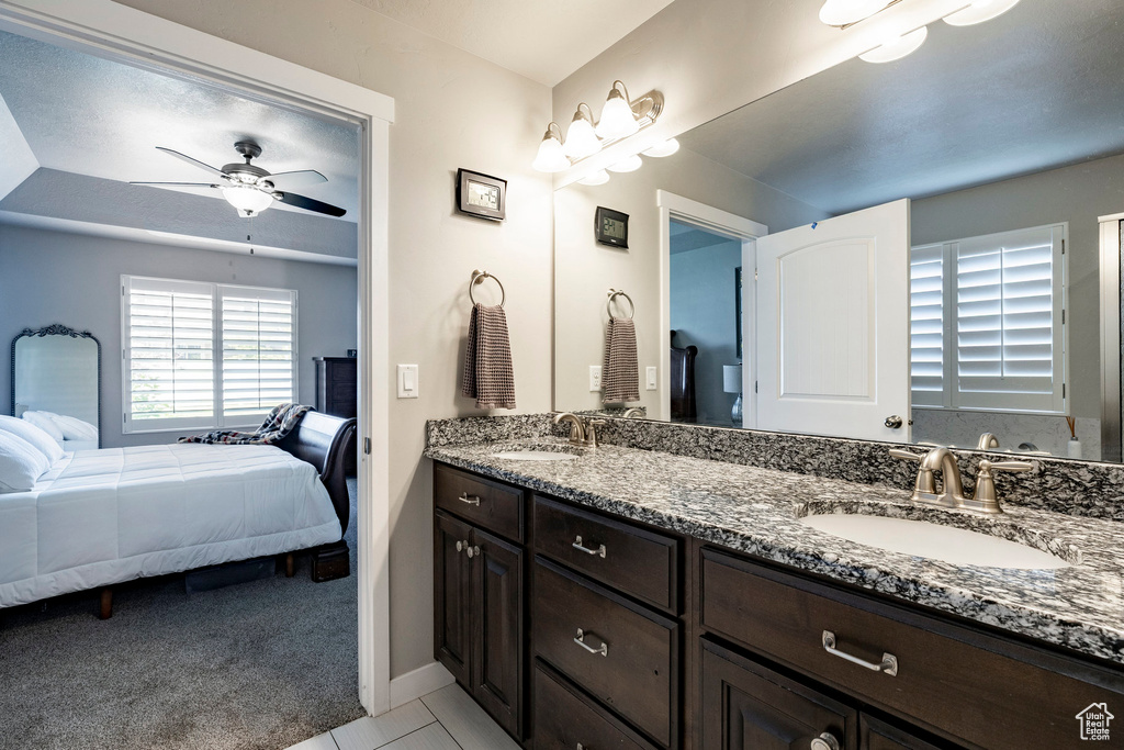 Bathroom with ensuite bath, double vanity, and ceiling fan