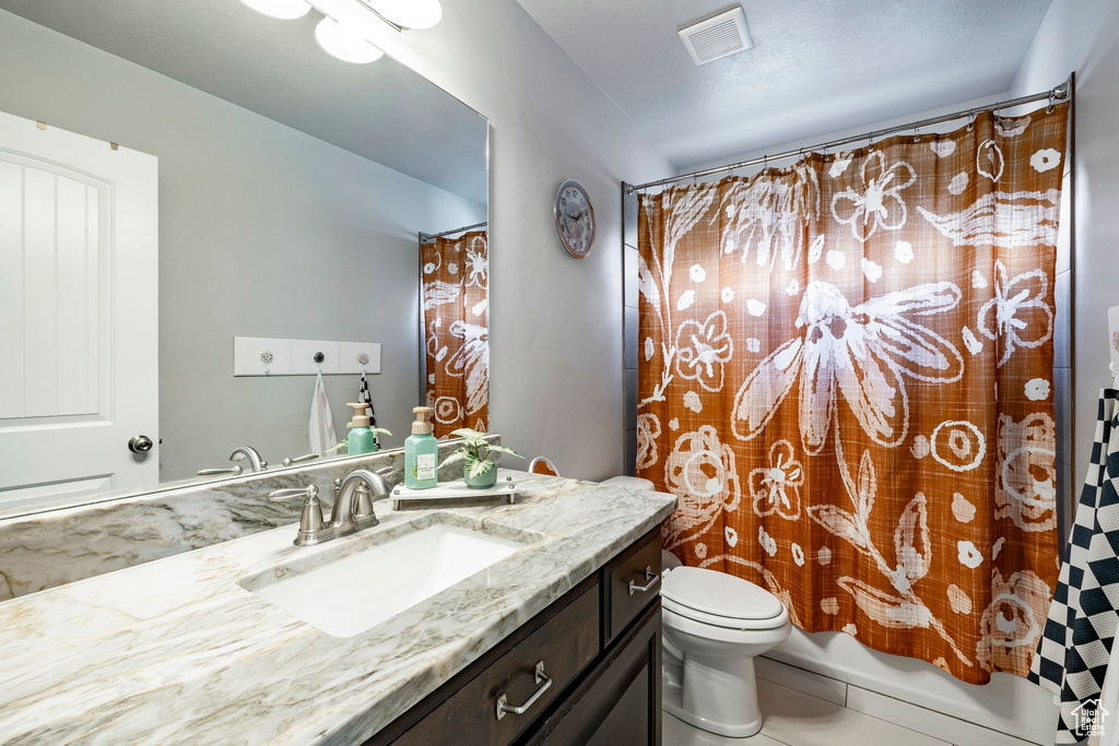 Bathroom featuring vanity and shower / bathtub combination with curtain