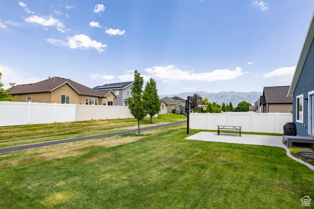 View of yard featuring a patio area, a residential view, and a mountain view