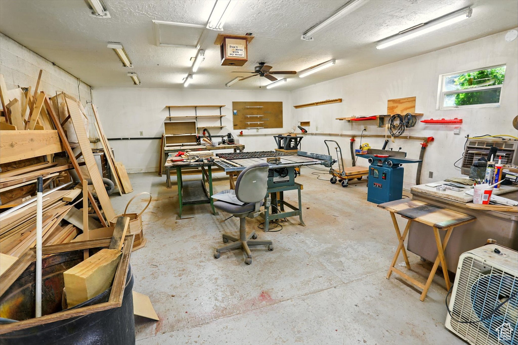Garage featuring a workshop area and a ceiling fan