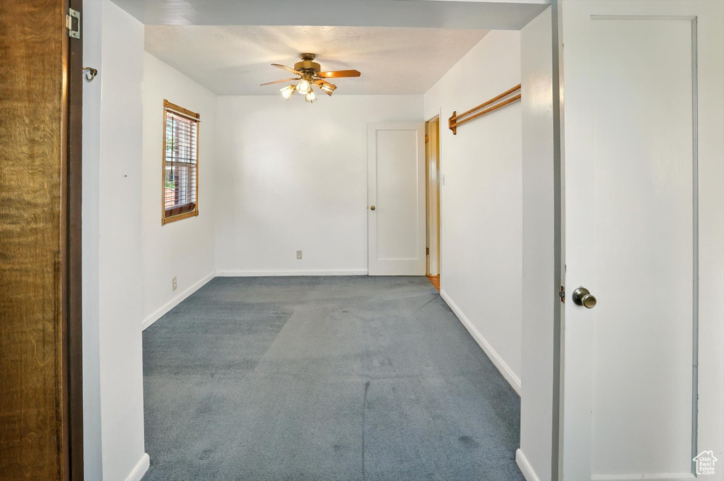 Empty room with ceiling fan and carpet flooring