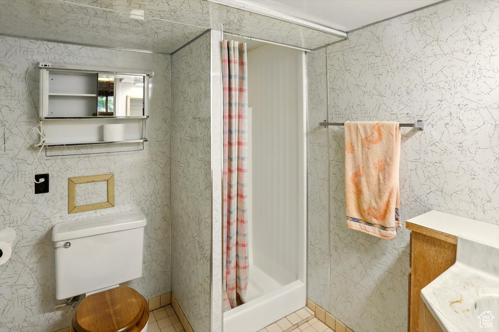 Full bath featuring a shower with shower curtain and tile patterned flooring