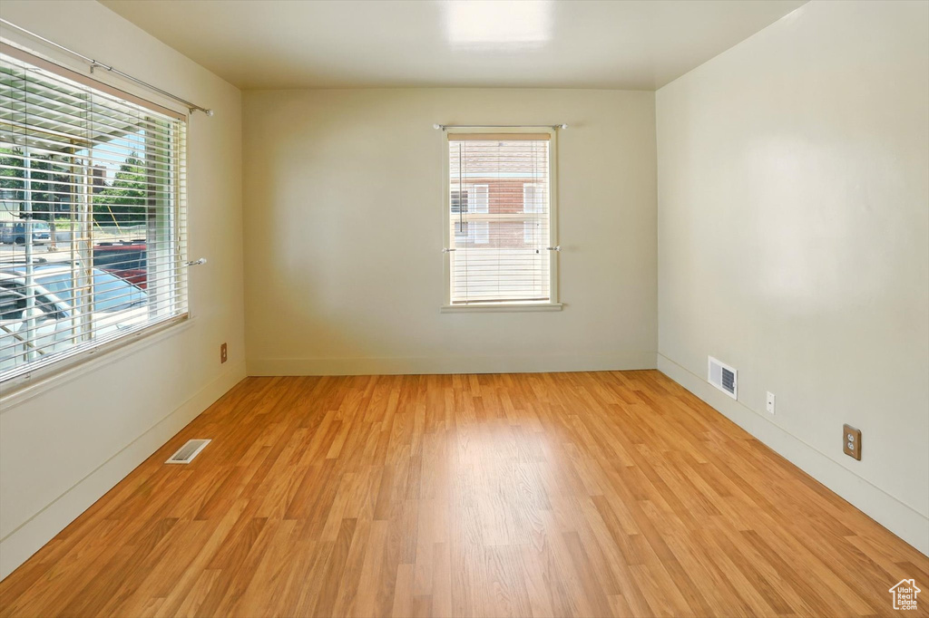 Empty room featuring light wood-type flooring and plenty of natural light