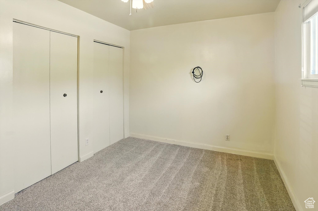 Unfurnished bedroom with carpet flooring and two closets
