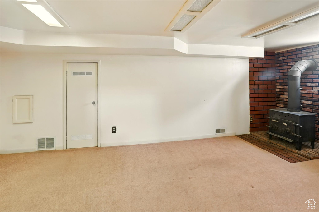 Finished below grade area with a wood stove and carpet floors