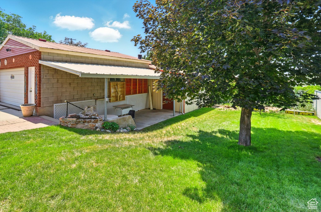 View of grassy yard featuring a garage