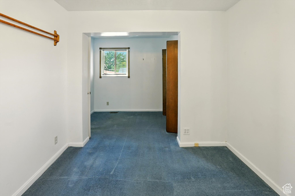 Unfurnished room featuring dark colored carpet