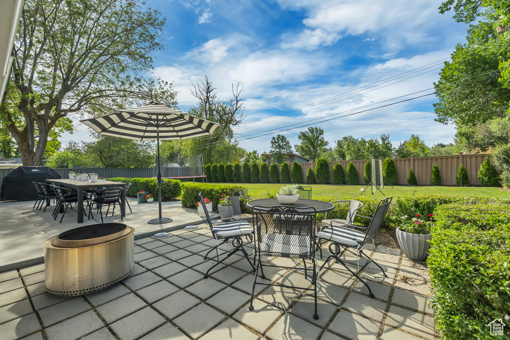 Fenced backyard with outdoor dining area, a patio, and a grill