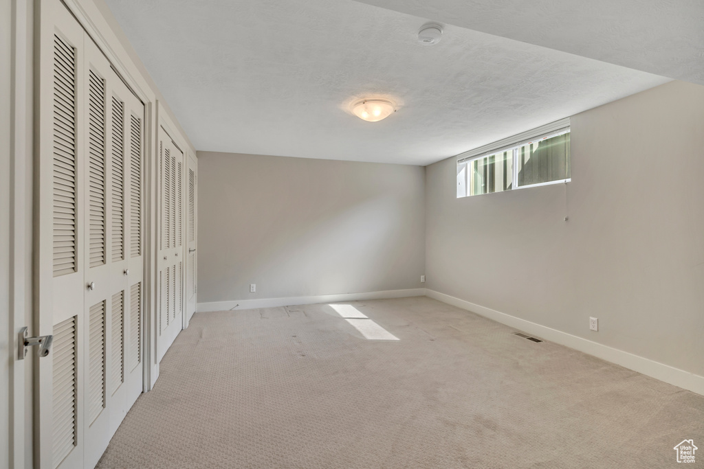 Unfurnished bedroom with two closets and light colored carpet