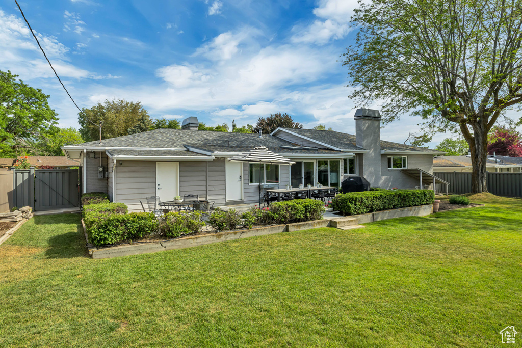 Back of property with a chimney, a gate, and a patio area