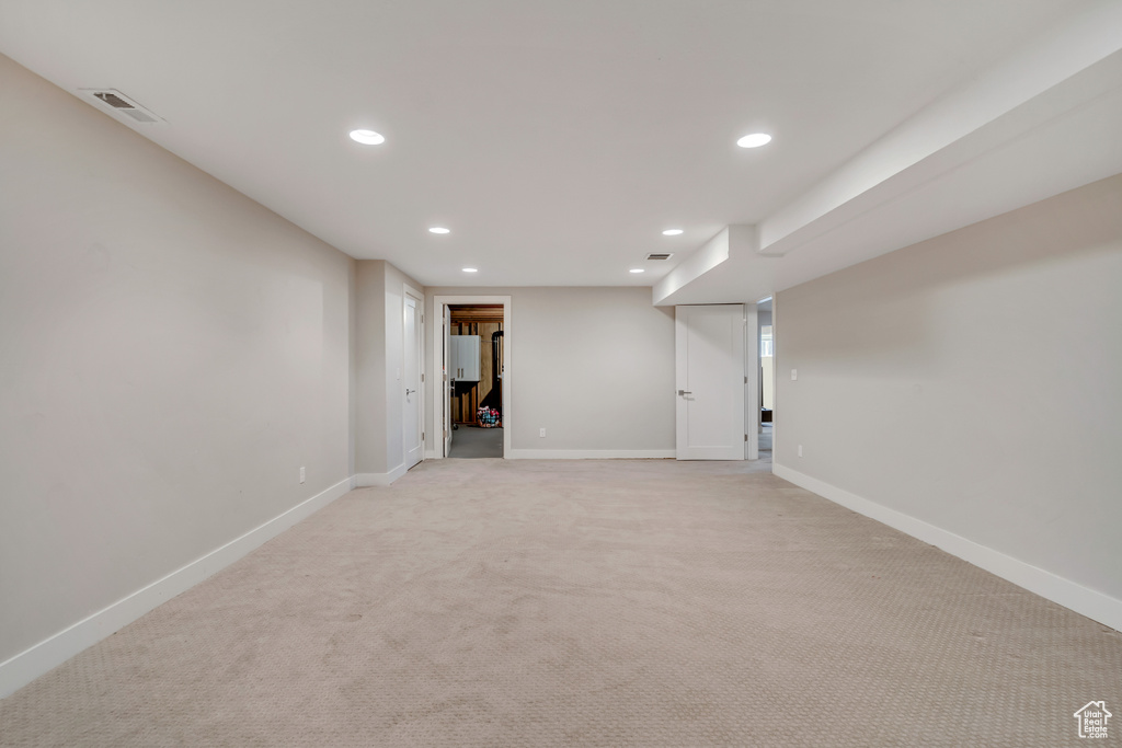 Finished basement with recessed lighting and light colored carpet