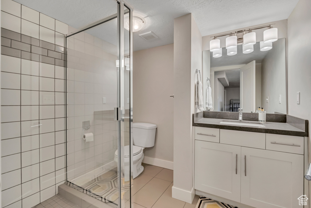 Bathroom with a shower stall, vanity, and tile patterned flooring