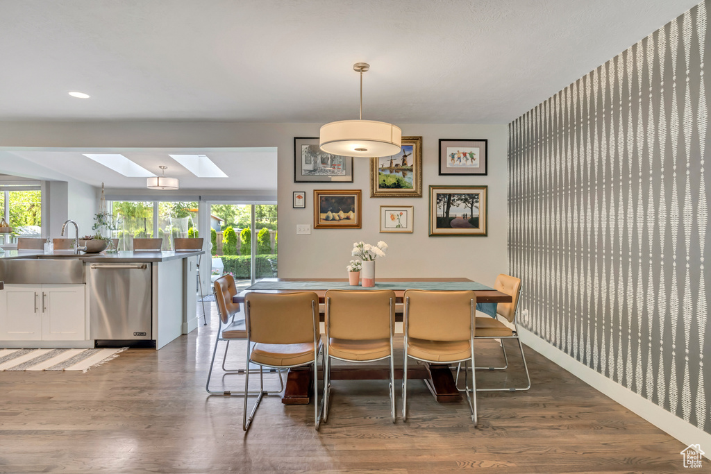Dining room featuring a skylight, wood finished floors, plenty of natural light, and recessed lighting