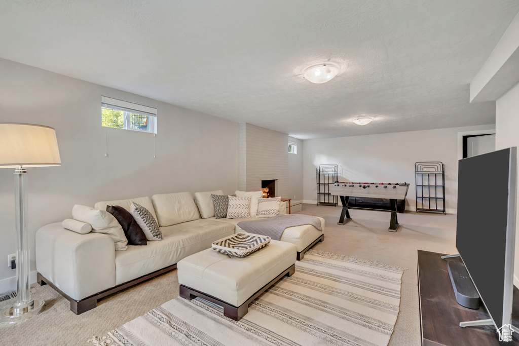 Living area with a fireplace and light carpet