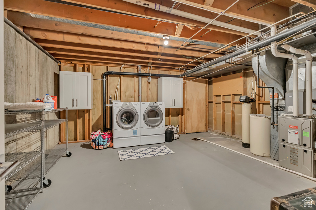 Unfinished below grade area featuring washer and clothes dryer and a water softener