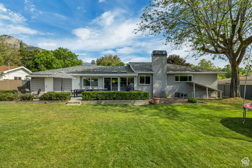 Rear view of house with a chimney and a patio