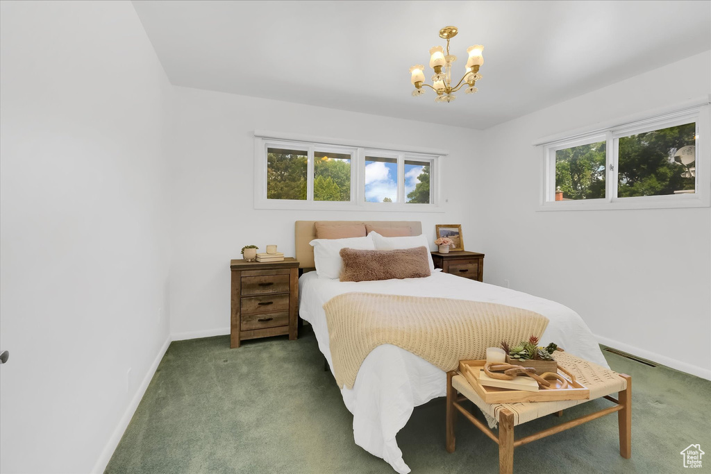 Bedroom featuring a chandelier and carpet floors