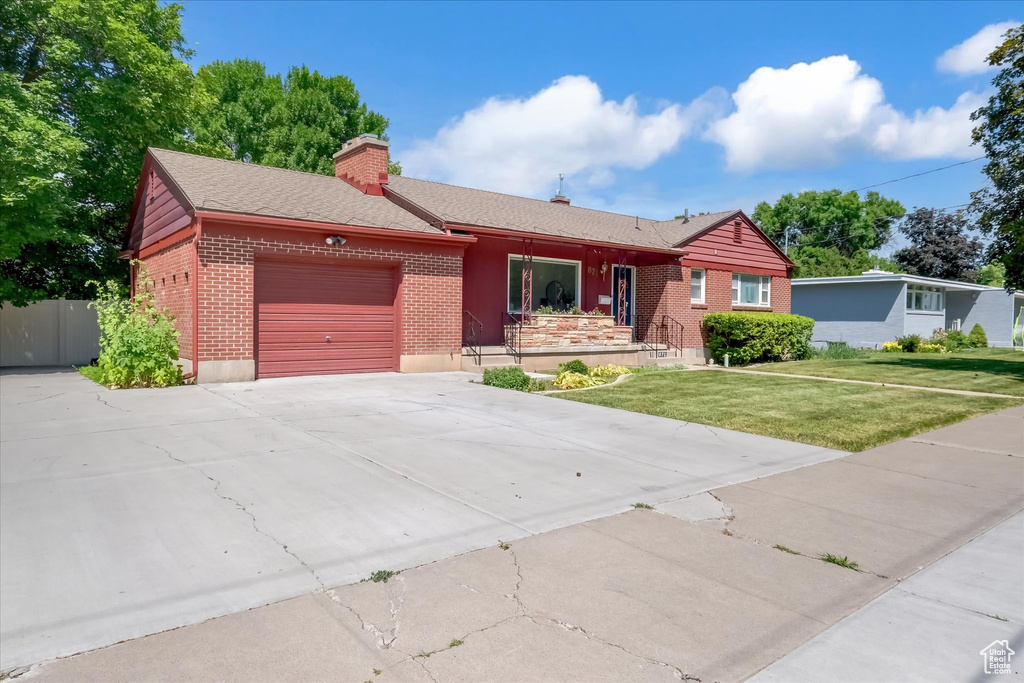 Single story home with brick siding, a garage, concrete driveway, a chimney, and a front lawn