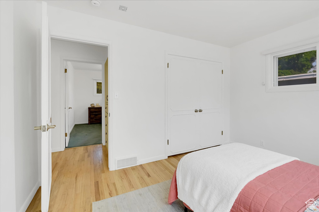 Bedroom featuring light wood finished floors and a closet