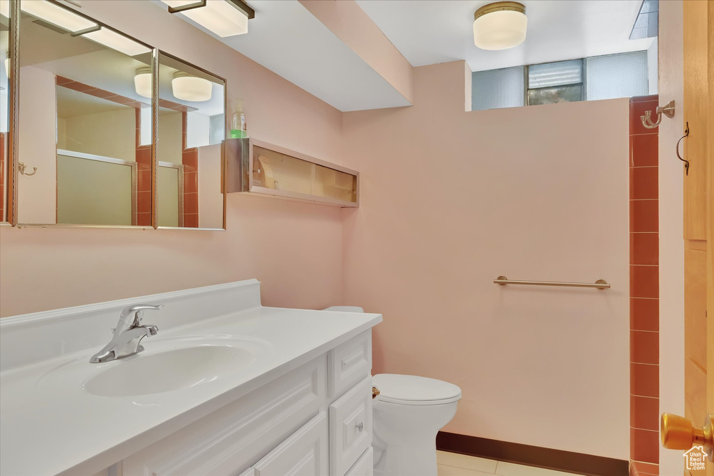 Bathroom featuring an enclosed shower, vanity, and tile patterned flooring