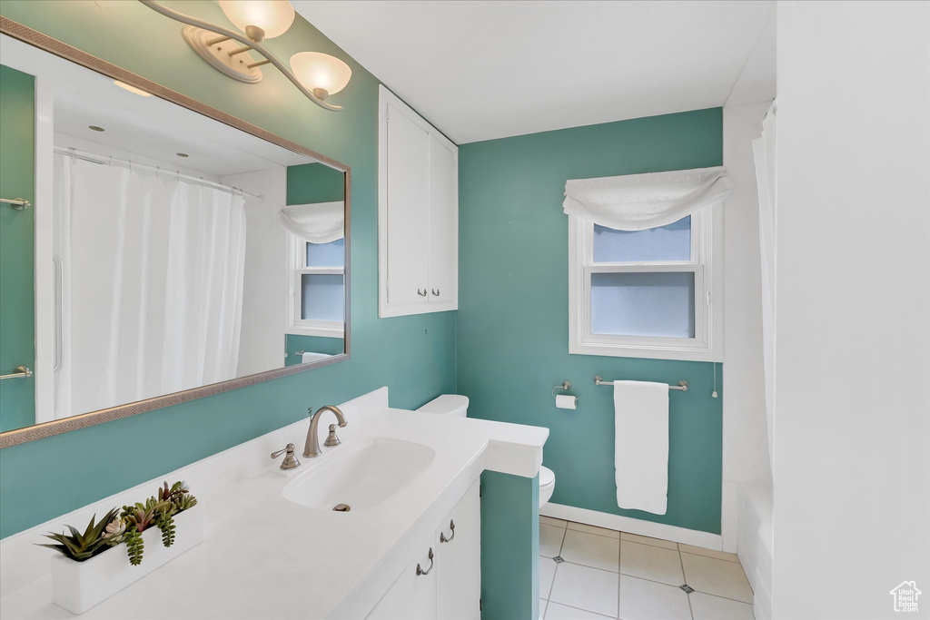 Bathroom with vanity, tile patterned floors, a shower with shower curtain, and a tub to relax in