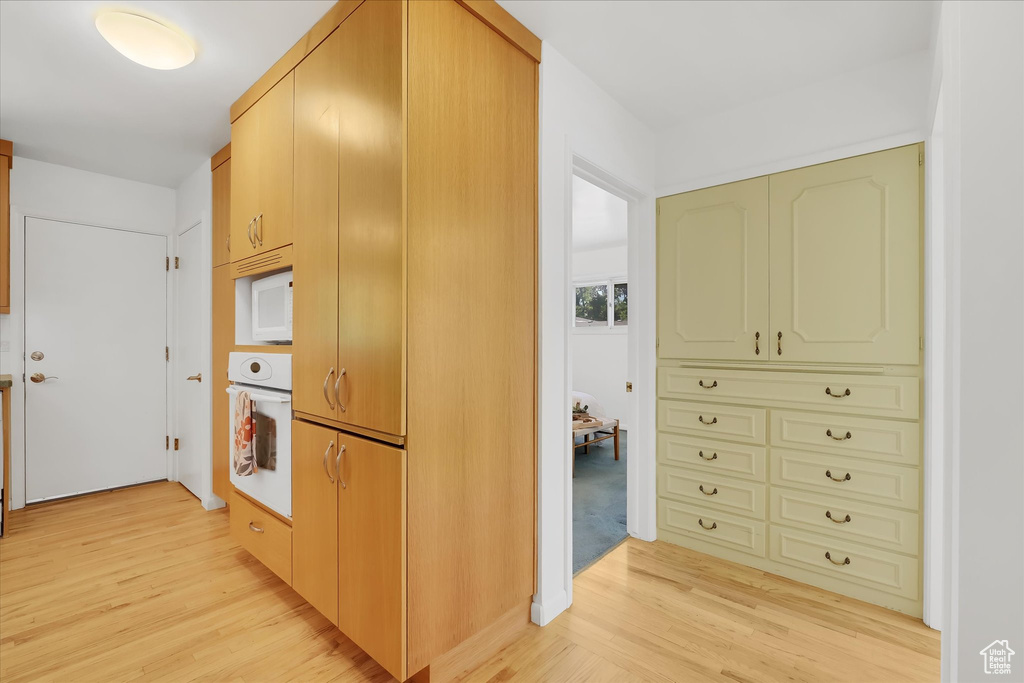 Kitchen featuring white appliances and light wood-type flooring